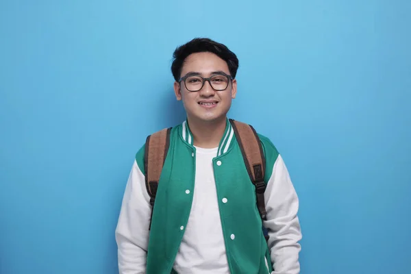 Joven estudiante asiático vistiendo chaqueta de béisbol verde sonriendo a la cámara — Foto de Stock