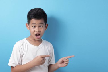 Asyalı çocuk bir şeyi kendi tarafına fotokopi aletiyle gösteriyor.