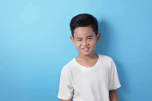 Söt asiatisk pojke tittar på kameran och ler glatt — Stockfoto