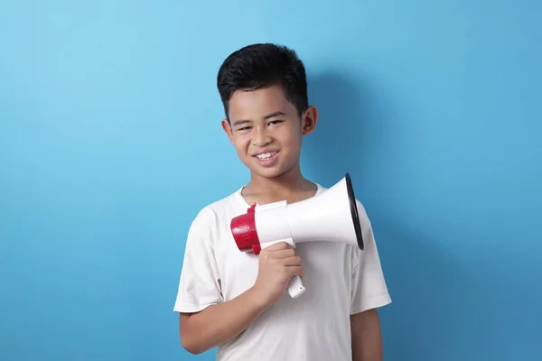 Feliz chico asiático sonriendo a la cámara mientras sostiene el megáfono — Foto de Stock