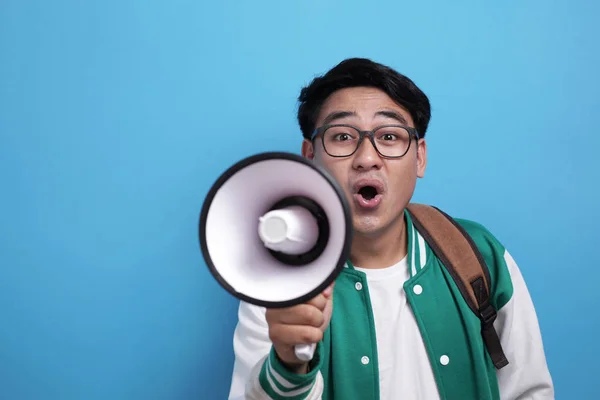 Junger asiatischer Student in grüner Baseballjacke brüllt auf Megafon — Stockfoto