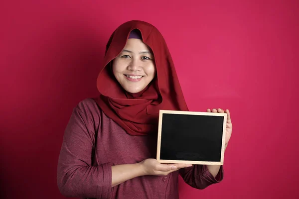 Intelligente asiatico musulmano donna sorridente a fotocamera e mostrando vuoto bll — Foto Stock