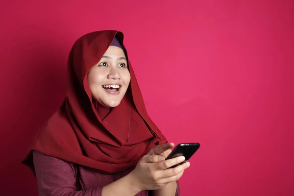 Muzułmańska kobieta zaskoczony, aby zobaczyć coś powyżej podczas korzystania z telefonu — Zdjęcie stockowe