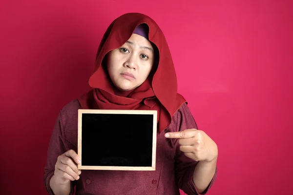 Bad mood angry annoyed Asian muslim woman shows empty blackboard — Stok fotoğraf