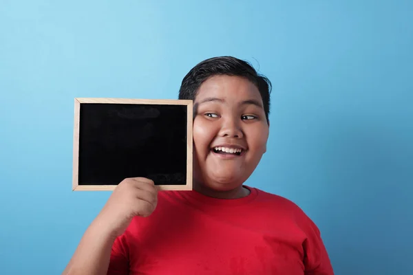 Gorda asiática chico sonriendo en cámara y mostrando vacío pizarra — Foto de Stock