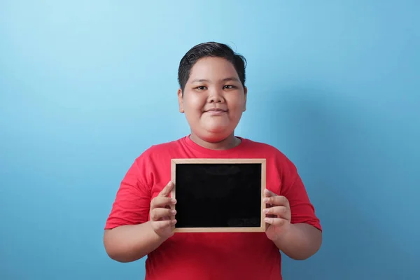 Gorda asiática chico sonriendo en cámara y mostrando vacío pizarra — Foto de Stock