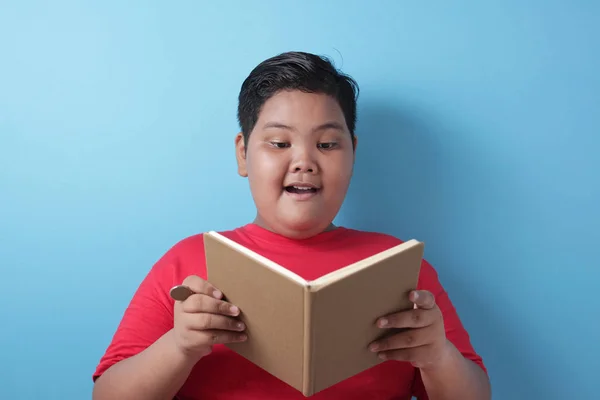 Fat Asian boy smiling happily when reading a book — 图库照片