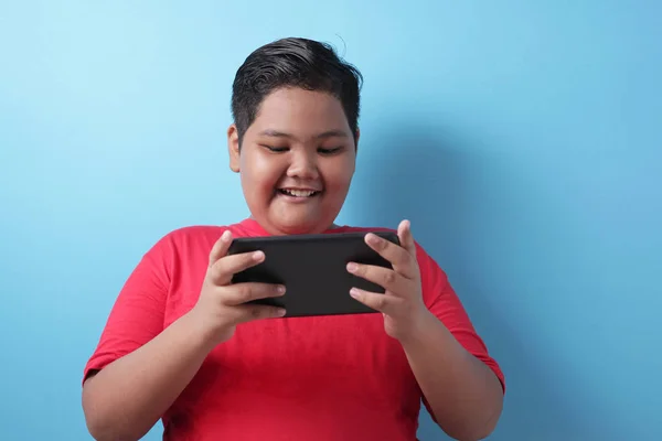 Gordo asiático chico juega en línea juego en su tableta gadget — Foto de Stock