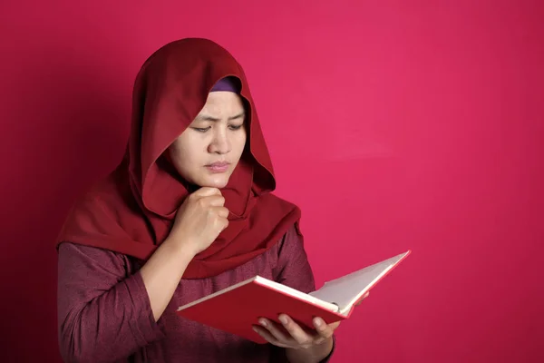 Мусульманская предпринимательница читает книгу с мыслящим жестом — стоковое фото
