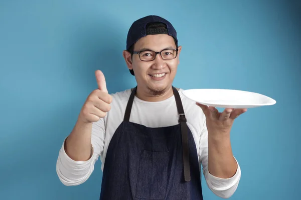 Asian Male Chef or Waiter Shows Empty White Plate, Presenting So