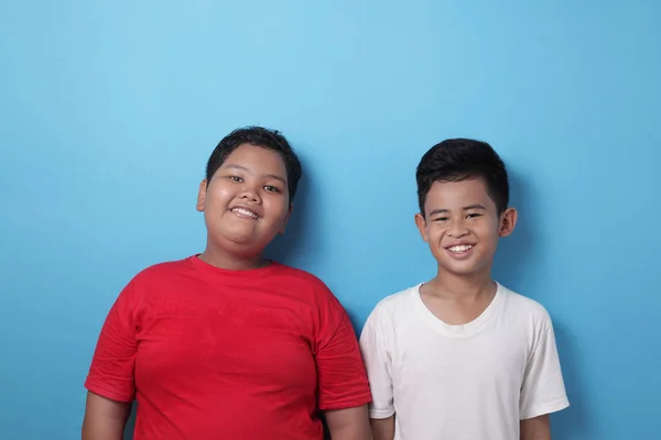 Dos chicos asiáticos mirando a la cámara, sonriendo y riendo, mejor fri — Foto de Stock