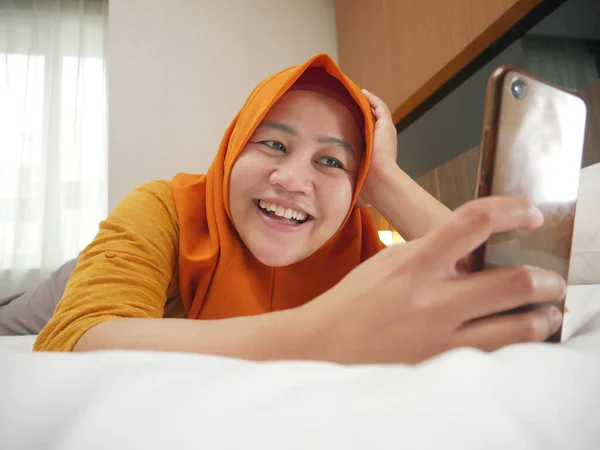 Wanita muslim Asia yang bahagia mengenakan jilbab tersenyum ketika membaca teks — Stok Foto
