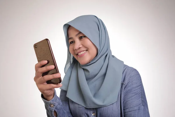 Junge muslimische Frau erhält gute Nachrichten auf ihrem Handy — Stockfoto