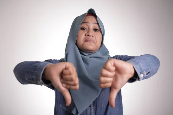 Muzulmán hölgy mutat hüvelykujjal legyőz gesztus, csalódott kifejezés — Stock Fotó