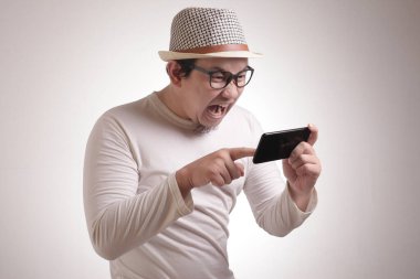 Komik genç Asyalı adam Tablet akıllı telefonda oyunlar oynamak