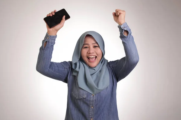 Junge muslimische Frau erhält gute Nachrichten auf ihrem Handy — Stockfoto