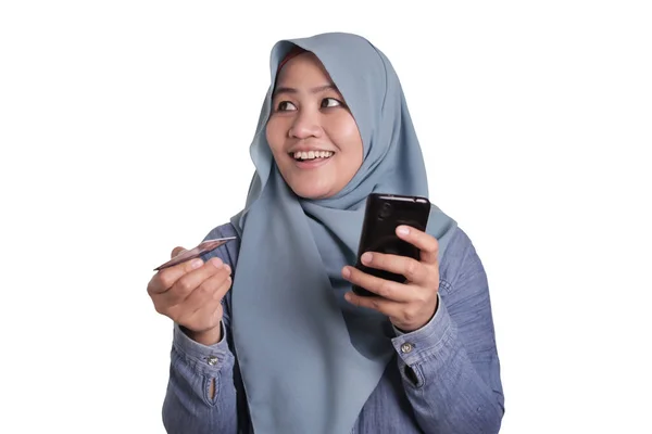 Мусульманка покупает онлайн через мобильный телефон — стоковое фото
