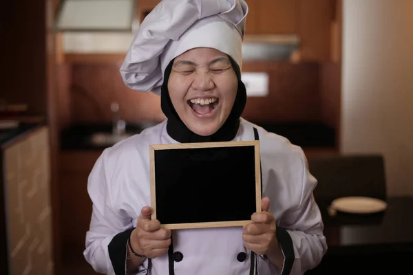 Aziatisch vrouwelijk chef-kok toont lege schoolbord, presenteren blank Writi — Stockfoto