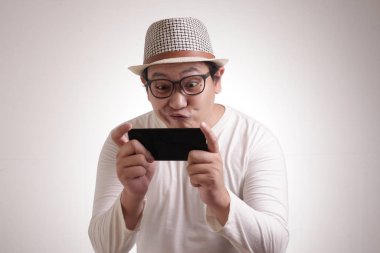 Komik genç Asyalı adam Tablet akıllı telefonda oyunlar oynamak