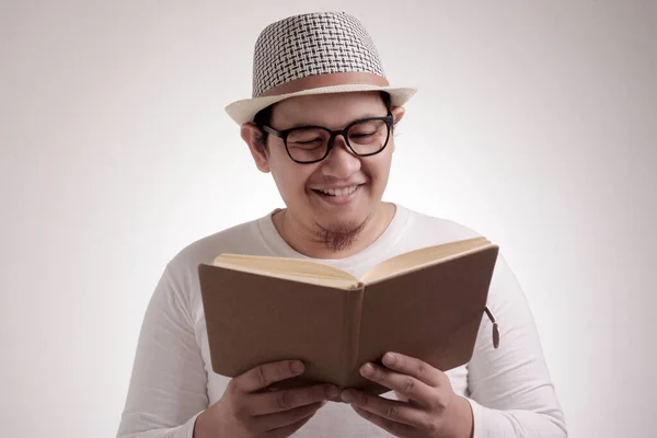 Hombre feliz sonriendo mientras lee el libro — Foto de Stock