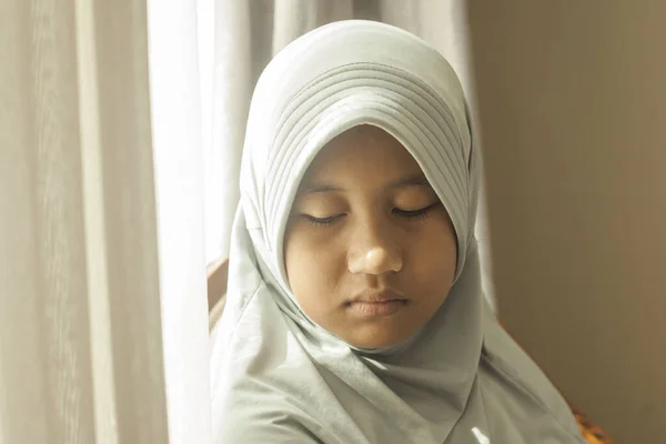 Portrait of sad muslim teenage girl looking down with empty look, sad lonely concept