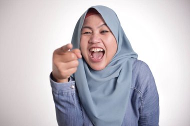 Zor gülüyor ve ileri, zorba ifade, işaret hijab giyen Müslüman kadın portresi yakın çekim kafa ile seçici odak vurdu