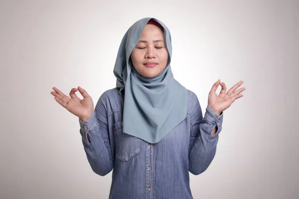 亚洲女性穆斯林女性的画像 头戴头巾 做放松瑜伽 闭上她的眼睛 宁静镇定放松的概念 — 图库照片