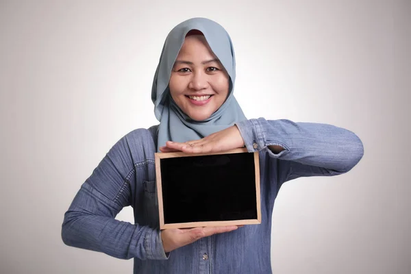 スマート幸せな成功したアジアのイスラム教徒の女性の肖像画を保持しながら カメラで笑みを浮かべてヒジャーブを身に着けているとコピースペースと空の黒板やチョークボードを表示 — ストック写真