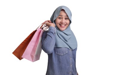 Mutlu Asyalı Müslüman kadın portresi, beyaz tüketim yaşam tarzı kavramına izole edilmiş alışveriş torbaları getiriyor.