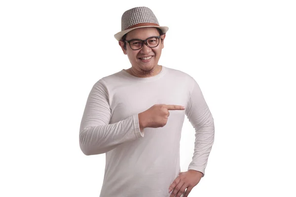 アジア系の若い男は身に着けている白いシャツ笑みを浮かべて コピー スペースと白い壁に 彼の側に何かを指しています ボディ肖像画を間近します — ストック写真