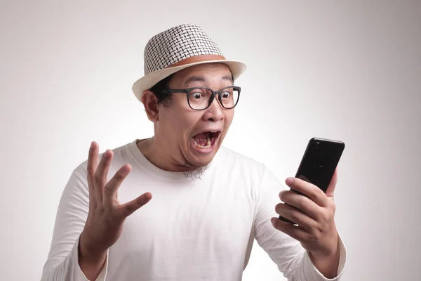 有魅力的年轻亚洲男人在阅读短信聊天时 惊讶的表情 — 图库照片