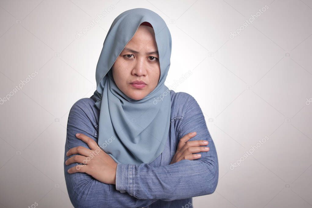 Portrait of cynical Asian muslim woman with suspicious expression looking and starring, mistrust misdoubt concept