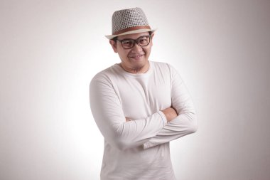 Çekici, kendine güvenen, mutlu gülümseyen, kollarını kavuşturmuş Asyalı bir adamın komik bir portresi.