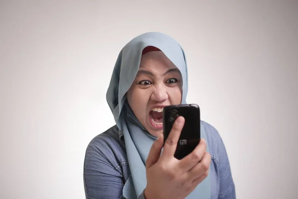 若いアジアのイスラム教徒の女性は 彼女の電話で叫んで 電話で怒っている 白い体の肖像画を閉じます — ストック写真