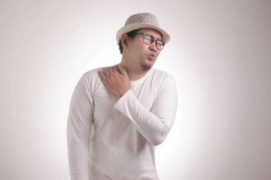 Beyaz gömlek giyen, boynu ağrıyan genç bir Asyalı. Vücut portresini kapat