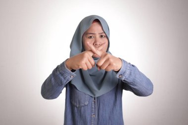 Portrait of muslim lady wearing hijab shows stop sign, prohibit forbid disallow something bad with crossed hand gesture