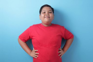 Komik yakışıklı Asyalı şişko çocuk kameraya gülümseyen koca göbeğini gösteriyor.