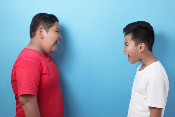 Två Asiatiska Pojkar Skriker Varandra Mot Blå Bakgrund Små Barn — Stockfoto