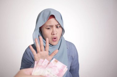 Endonezyalı Müslüman kadının portresi Rupiah parasını reddediyor, rüşvet kavramından kaçıyor.