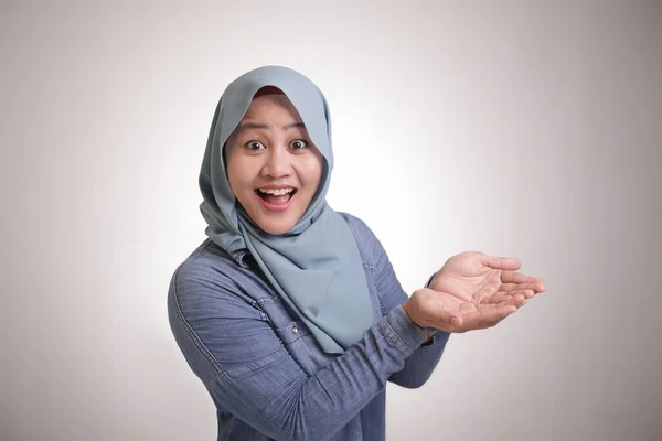 ヒジャーブを身に着けて空の手に何かを示すアジアのイスラム教徒の女性の肖像画 コピースペーステンプレートの概念を提供します — ストック写真