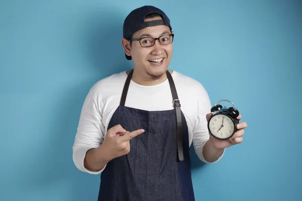 年轻的亚洲男性厨师或侍者对着摄像机笑着 带着快乐的表情和时间管理 在蓝色背景下按时出现 — 图库照片
