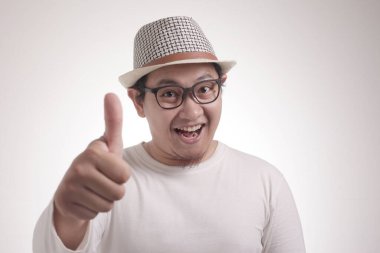 Beyaz gömlek gülümseyen komik çekici sevimli genç Asyalı adam Fotoğraf görüntü portre gülümseyerek ve işaret kadar başparmak gösteren, seçici odak ile yarım vücut portresi