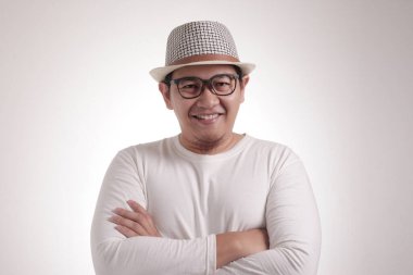 Çekici, kendine güvenen, mutlu gülümseyen, kollarını kavuşturmuş Asyalı bir adamın komik bir portresi.