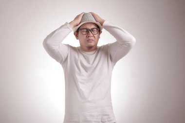 Komik Asyalı adamın resmi. Gözlerini kapat, depresyon, hayal kırıklığı, umutsuz surat ifadesi.