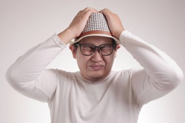 Komik Asyalı adamın resmi. Gözlerini kapat, depresyon, hayal kırıklığı, umutsuz surat ifadesi.