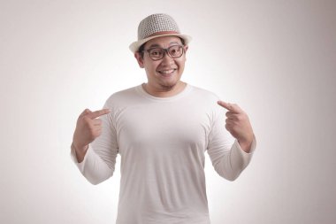 Gülümseyen ve kendini gösteren mutlu Asyalı portresi, güven konsepti, beyaz arka plana karşı portreyi kapat