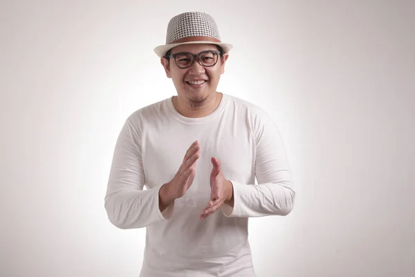 Young Asian man wearing white shirt, happy proud clapping gesture.Over grey background, halfl body portrait