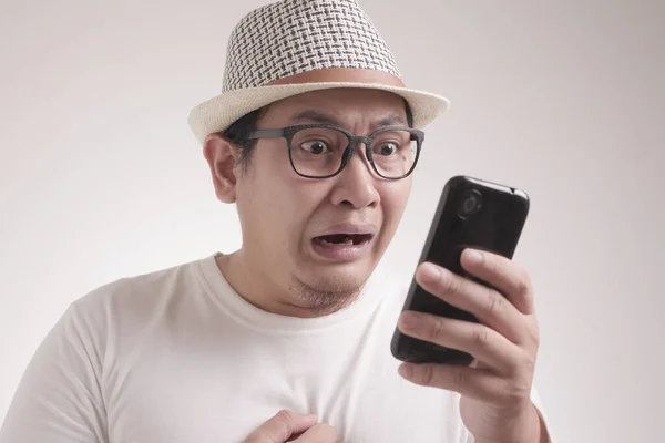 魅力的な若いアジアの男は 彼の電話でチャットのテキストメッセージを読んで 悪いニュース 悲しい泣き式 — ストック写真
