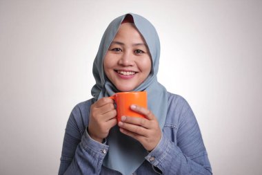Kahve molası sırasında çay veya coffe içme, gülümseyen mutlu genç güzel Asya müslüman kadın Portresi