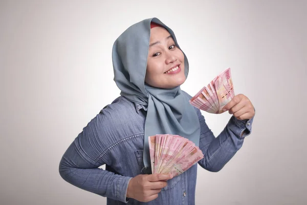 Portret Indonezyjskiej Muzułmanki Trzymającej Pieniądze Rupii Uśmiechnięty Uśmiech Zwycięski Gest — Zdjęcie stockowe